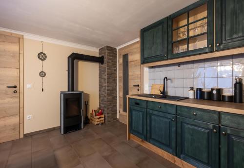 a kitchen with green cabinets and a counter top at Heimathaus Hettegger neue gemütliche Ferienwohnung in Grossarl