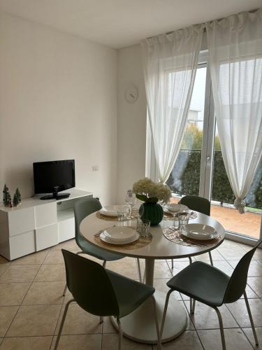a dining room with a table and chairs and a television at Bilocale vicino a Como in Mozzate