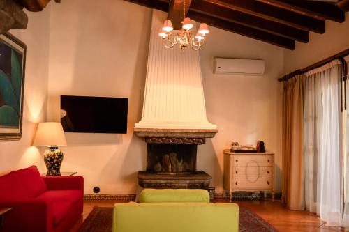 a living room with a fireplace and a red couch at Las Mañanitas in Cuernavaca