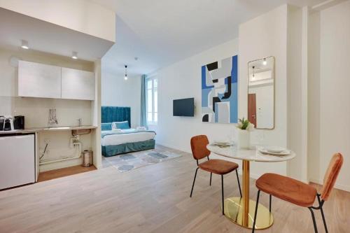 a kitchen and living room with a table and chairs at La lumière de Paris in Levallois-Perret