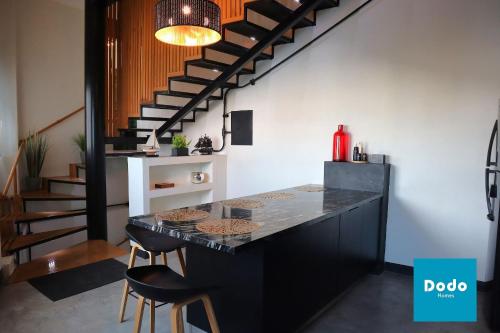 a kitchen with a black counter and a staircase at Casa en Mazatlan con alberca privada en centro historico in Mazatlán