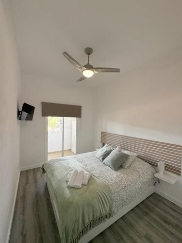 una camera bianca con letto e ventilatore a soffitto di Salitreja a Puertito de Güímar