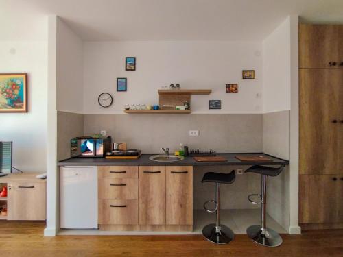 a kitchen with a counter and a sink and stools at Planet Residence-Studio Solis in Niš