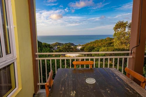 a table on a balcony with a view of the ocean at Cathartica in Quatre Vents