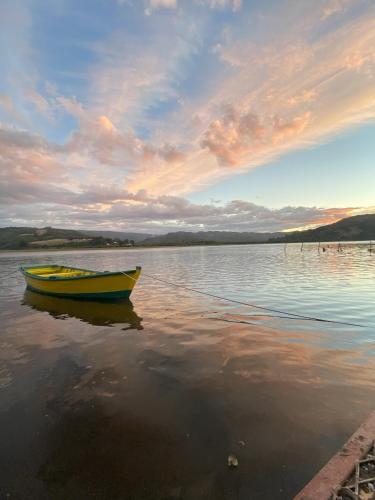 a yellow boat sitting on a body of water at Mehuín el Remanso de Paz in Mehuín