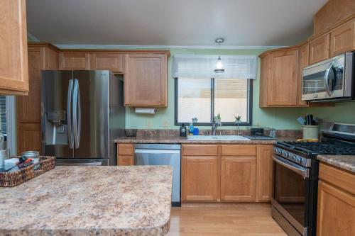 a kitchen with wooden cabinets and a stainless steel refrigerator at Buckskin Tango, Views! in Parker