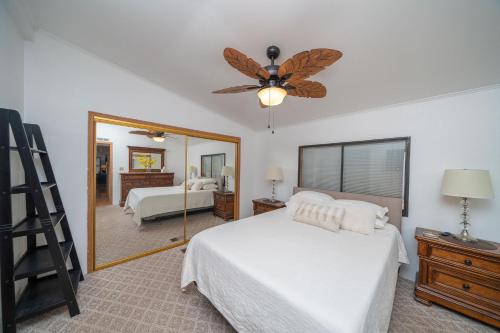 a bedroom with a bed with a ceiling fan and a mirror at Buckskin Tango, Views! in Parker