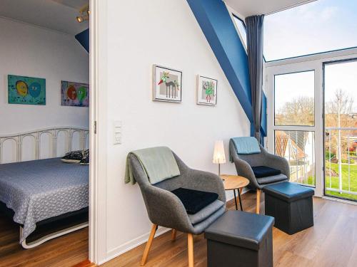 4 person holiday home in Hejls-By Traum في Hejls: غرفة نوم بها سرير وكرسيين وطاولة