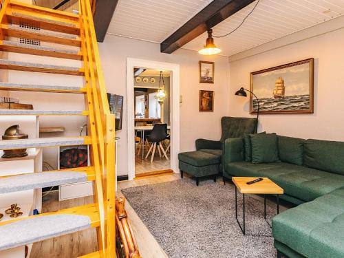 a living room with a green couch and a ladder at 4 person holiday home in Marstal-By Traum in Marstal