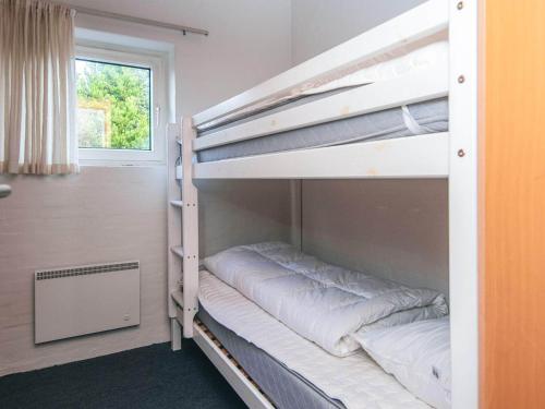 a room with two bunk beds with a window at 6 person holiday home in Blåvand-By Traum in Blåvand