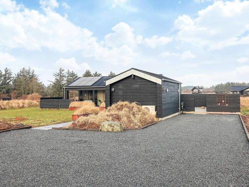a black house with a pile of hay in front of it at 5 star holiday home in Hirtshals-By Traum in Hirtshals