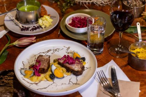 a table with plates of food and glasses of wine at Hotel Don Raul in San Pedro de Atacama