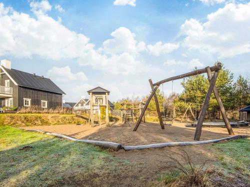 a playground with a wooden swing set in a yard at 8 person holiday home in Gjern in Gjern