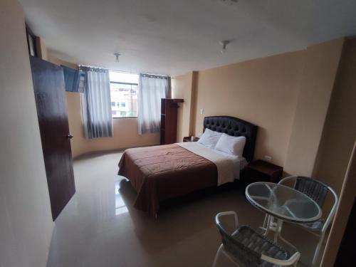 ein Hotelzimmer mit einem Bett und einem Tisch in der Unterkunft Hotel El Gran Patriarca in Cajamarca