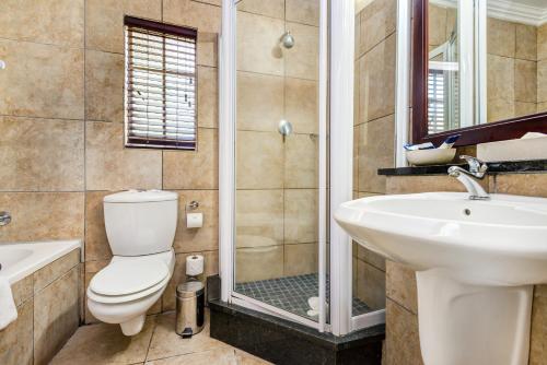 a bathroom with a toilet and a sink and a shower at Hazyview Sun in Hazyview