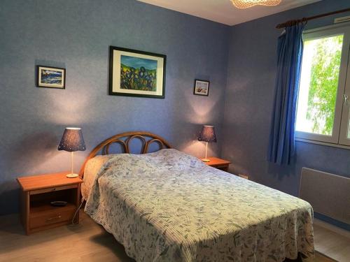 a bedroom with a bed and two tables and two lamps at Maison tranquille avec jardin et wifi, 3 chambres - FR-1-336-116 in Avrillé