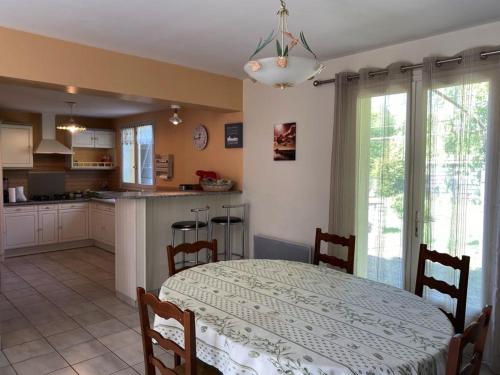 une cuisine et une salle à manger avec une table et une table et des chaises dans l'établissement Maison tranquille avec jardin et wifi, 3 chambres - FR-1-336-116, à Avrillé