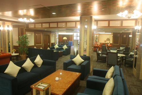 a waiting room with blue couches and a table at Harbor Hotel Kaigetsu in Sumoto
