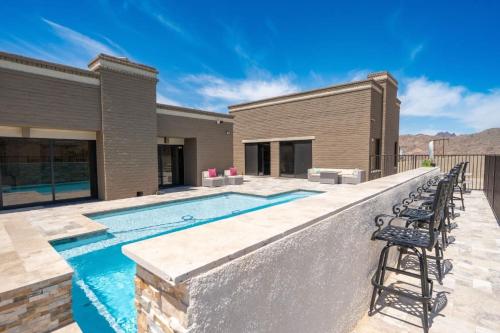 a swimming pool with chairs next to a house at Eagles Lair, Poolside Luxury! in Parker