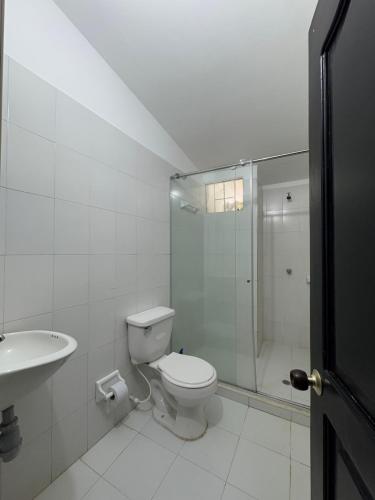 a bathroom with a toilet and a shower and a sink at Finca San José, Los Naranjos Santa Marta in Santa Marta