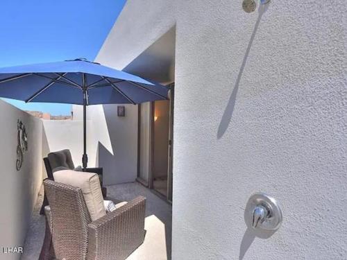 a door with a chair and an umbrella on a patio at Kastle on the Keys, private dock in Parker