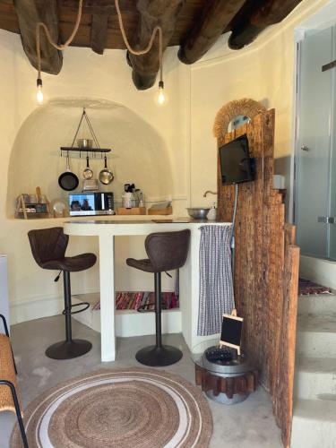 a kitchen with a counter and stools in a room at Moinho da Boavista in Serra do Bouro