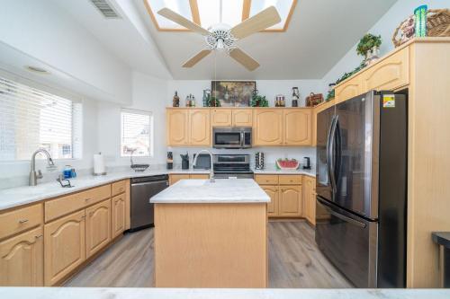 a kitchen with wooden cabinets and a black refrigerator at Oceans 11, 60-FT Dock in Parker