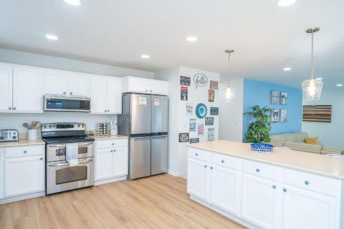a kitchen with white cabinets and stainless steel appliances at Ohana Beach, Paradise Escape in Parker