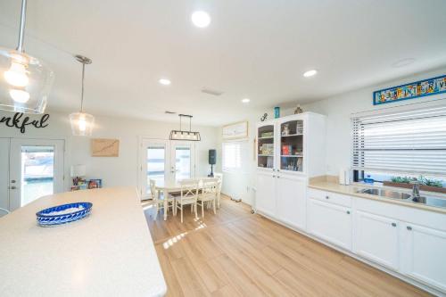 a kitchen with white cabinets and a table and a dining room at Ohana Beach, Paradise Escape in Parker