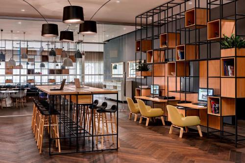 a room with tables and chairs and a library at Courtyard by Marriott Brno in Brno