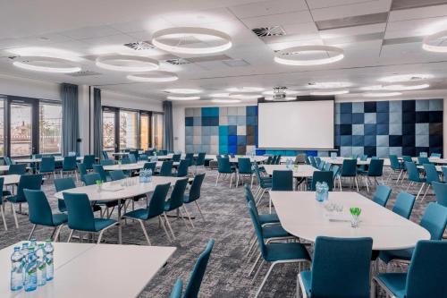 a conference room with tables and chairs and a whiteboard at Courtyard by Marriott Brno in Brno