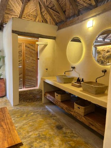 a bathroom with two sinks and two mirrors at Hotel Aldea Guane in Los Santos