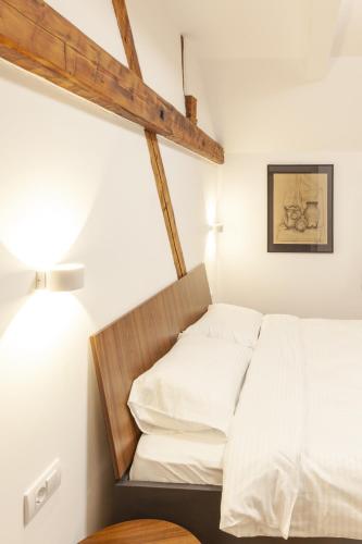 a bedroom with a bed with white sheets and a lamp at Prenoćište Omega Luxury in Čačak