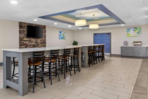 a lobby with a bar with stools and a tv at Best Western Atlanta Cumberland Galleria Hotel in Atlanta