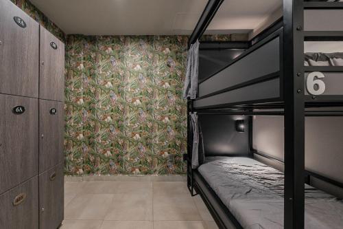 a bedroom with two bunk beds and a wallpaper at Cozy Bed in mixed room in Mexico City