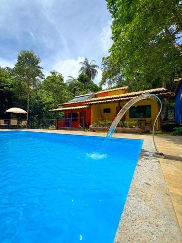a pool with a water fountain in front of a house at Pousada Cigarras da Serra in Serra do Cipo