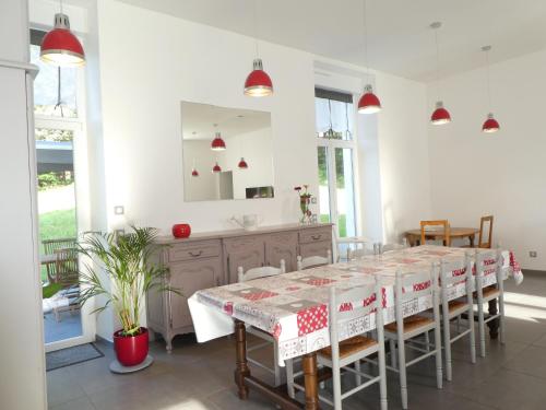 une salle à manger avec une table et un miroir dans l'établissement Maison de campagne tout confort avec jardin, à 15 min d'Épinal, idéale pour familles et randonneurs - FR-1-589-372, à Uriménil