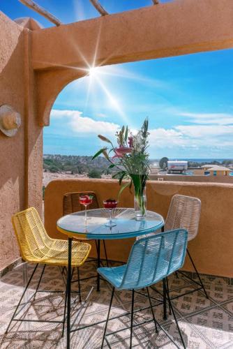 a table with chairs and a vase of flowers on a balcony at Appartement Taghazout in Taghazout