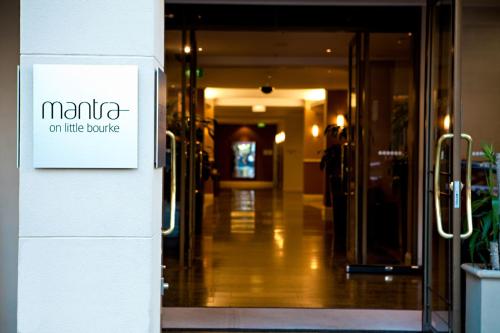 an entrance to a building with a sign on the door at Mantra on Little Bourke Melbourne in Melbourne