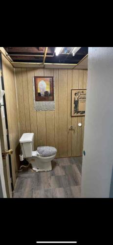 a bathroom with a toilet in a wooden wall at Tarawa drive in Cincinnati