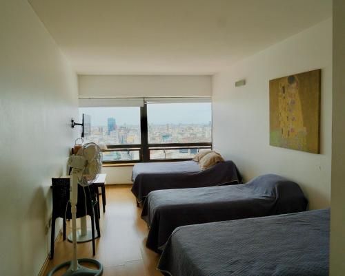 3 camas en una habitación con vistas a la ciudad en RANCHO TANGUERO EN EL OBELISCO en Corrientes 818, en Buenos Aires