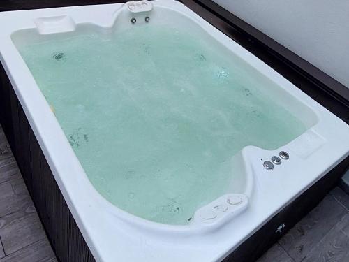 a white bath tub filled with green water at departamento boutique centrico- villa carlos paz in Villa Carlos Paz
