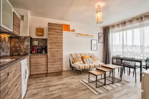 une cuisine et un salon avec un canapé et une table dans l'établissement COZY beautiful seaside apartment, à Villers-sur-Mer