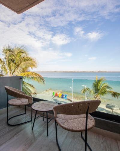 ein Balkon mit zwei Stühlen und Blick auf den Strand in der Unterkunft Malecón 1680 in La Paz