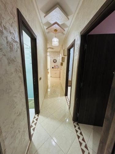 a hallway with a black door and a tile floor at Jardins Anass 3 Aéroport Marrakech in Marrakech
