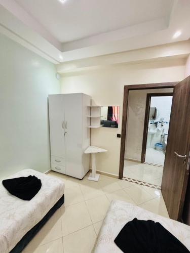 a white room with two beds and a mirror at Jardins Anass 3 Aéroport Marrakech in Marrakech