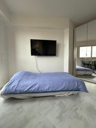 a bedroom with a bed with a tv on the wall at Apartment HOME in Paris with View, 15min direct to center in Paris