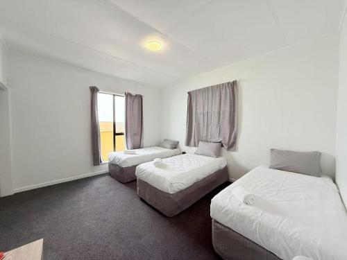 a hotel room with two beds and a couch at Unit 11 Fenton Summer Lodge Rotorua in Rotorua