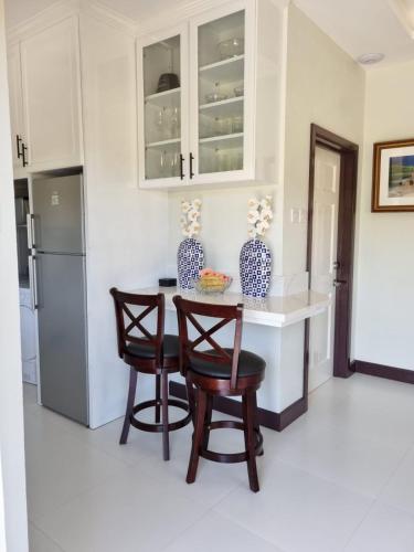 une cuisine avec une table, deux chaises et un réfrigérateur dans l'établissement The Swallow Nest 2, à Gros Islet