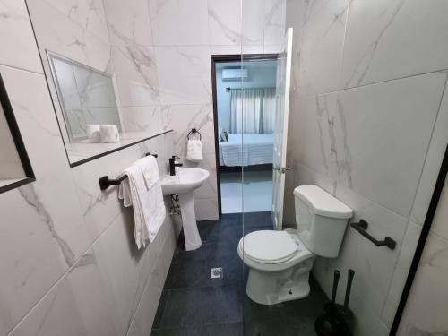 une salle de bains blanche avec toilettes et lavabo dans l'établissement The Swallow Nest 2, à Gros Islet